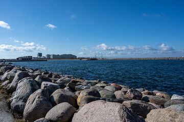 An ocean bay with big boulders as a wave breaker in the foreground. Picture from Malmo, soutrhern Sweden