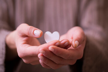 Woman hand holding white heart toy. Love concept. 