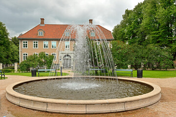 City landscape with fountain in old park on gloomy day. Oslo, Norway