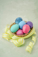 colorful easter eggs with yellow ribbon on green with copy space