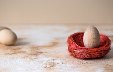 One Easter egg in a decorative nest on a neutral pastel background. Minimalistic trendy close up composition with space for text. Happy Easter greeting card 