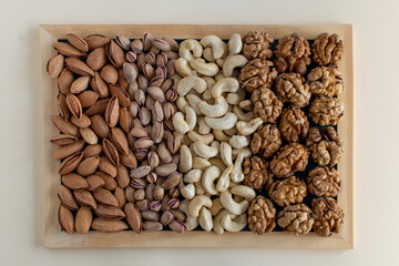 Assorted nuts: almonds, pistachio, cashews, walnut . Vegetarian snack. Flatlay organic mixed nuts background. Healthy food, useful microelements and vitamins. Useful health snack.