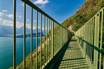 Panoramic view on Lake Garda from the Busatte-Tempesta trail near Nago-Torbole with the iron staircase,  Torbole  town surrounded by mountains in the summer time,Italy