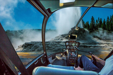 Helicopter cockpit flight over Castle Geyser with hot water and steam pools of thermophilic bacteria and cone geyser in Upper Geyser Basin of Yellowstone National Park, Wyoming, United States.