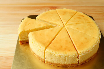 Delectable creamy baked cheesecake with a slice cut from whole cake