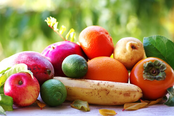  persimmon, pomegranate, apple, other fruits and leaves on the table