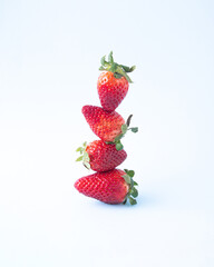 Strawberries vertically arranged on a light blue background.