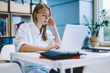 Fototapeta premium Focused woman working on laptop