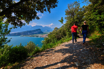 Panoramic view on Lake Garda from the Busatte-Tempesta trail near Nago-Torbole with the iron staircase,  Torbole  town surrounded by mountains in the summer time,Italy