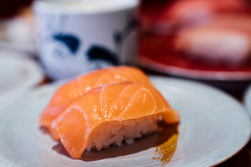 Sushi and Sashimi. Dishes of Sushi and Sashimi rolling on conveyer belt.