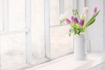 beautiful tulips on old white windowsill