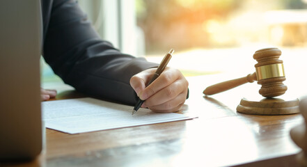 Legal counsel presents to the client a signed contract with gavel and legal law. justice and lawyer concept .