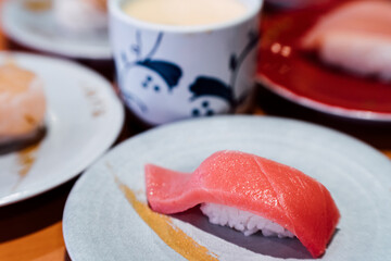 Sushi and Sashimi. Dishes of Sushi and Sashimi rolling on conveyer belt.