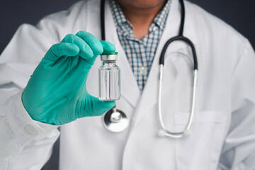 A doctor holding a vaccine bottle. Vaccine for immunization, and treatment from virus infection. Front view. Concept of medical and the fight against the virus