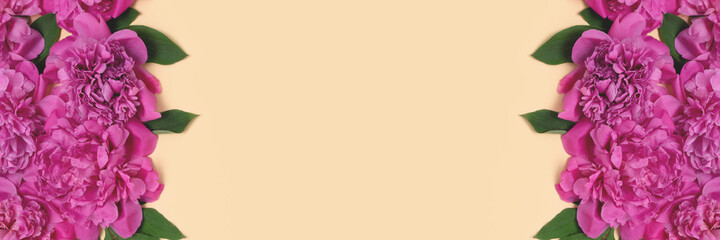 Banner with frame made of peony flowers texture and green leaves on a beige background. Floral concept with copyspace.