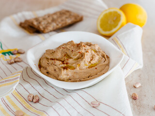 Hummus of borlotti beans and sun-dried tomatoes in a white bowl. Vegan recipe