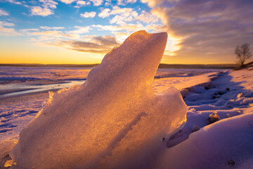 Beautiful melting ice at frozen lake again winter sunset