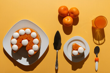 Tangerine cheesecake with meringue discs on white square plate, three tangerines, glass of juice,...