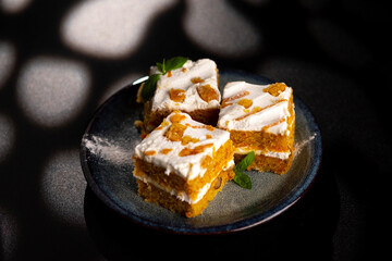 Carrot dessert cake on a plate on a black background.