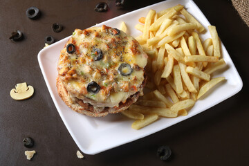 Pizza burger with fries on wooden table