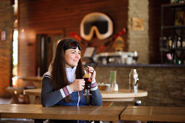 girl resting and drinking hot tasty mulled wine in a cafe ski resort