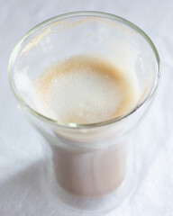 A double glass cup of cappuccino 