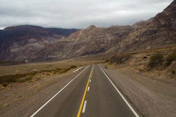 Fototapeta na wymiar Road trip into the arid desert. Traveling along the asphalt highway across the rocky mountains. 