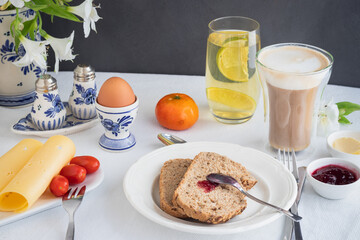 Breakfast table with bread, coffee, cheese, egg, jam
