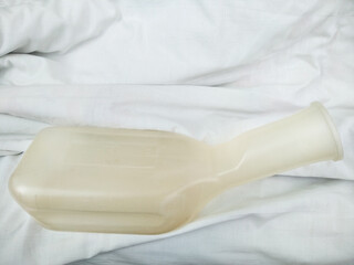 Urinal pot in the hospital. Lying patient after surgery in a hospital bed. Medical theme. Medical equipment for patients in Ukrainian hospital.