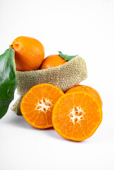 Ripe fresh juicy tangerines with leaves on white background