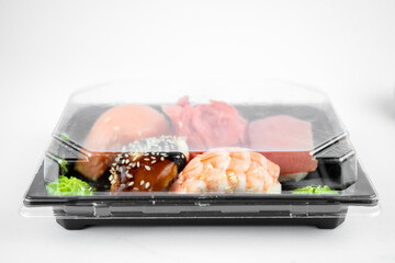 take away sushi in plastic container, pink ginger, wasabi. sushi delivery concept