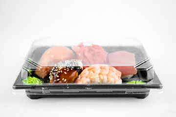 take away sushi in plastic container, pink ginger, wasabi. sushi delivery concept