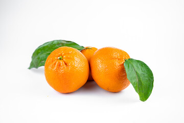 Ripe fresh juicy tangerines with leaves on white background