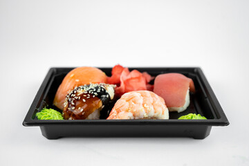 take away sushi in plastic container, pink ginger, wasabi. sushi delivery concept