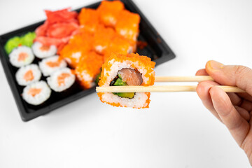 take away sushi rolls in plastic container, california, salmon maki roll, pink ginger, wasabi. sushi delivery concept