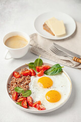 Eggs, buckwheat, tomatoes and spinach on a plate, coffee in cup. Healthy breakfast.