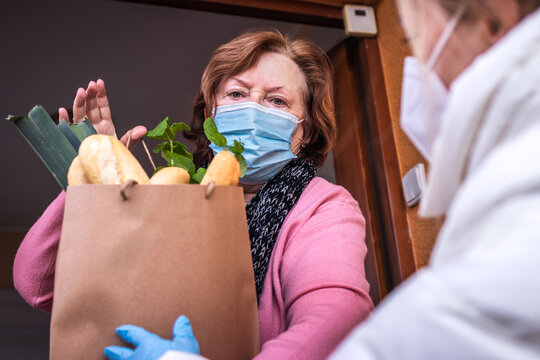 Volunteer Wearing Ffp2 Mask During Delivering Groceries To Senior Woman. Support Local Elderly Community Due Covid-19 Lockdown. Helping Hand With Shopping Food During Coronavirus Pandemic