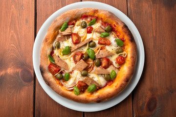 Deliziosa pizza gourmet con tonno pinne gialle, cipolle, pomodorini, olive e basilico fresco 