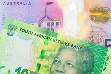 A macro image of a shiny, green 10 rand bill from South Africa paired up with a colorful five dollar bill from Australia.  Shot close up in macro.