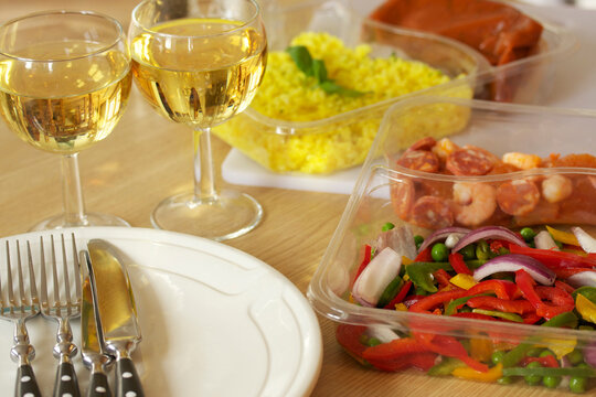 Uncooked Pre Prepared Meal With Fresh Prawns, Chorizo, Peppers, Red Onion And Rice, Arranged With White Wine, Plates And Cutlery