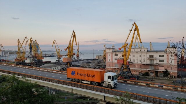 Overpass road and cargo vehicle truck with Hapag-Lloyd container. Maritime port landscape in harbor of European Black sea coast. Odessa, Ukraine, 10 20 2020