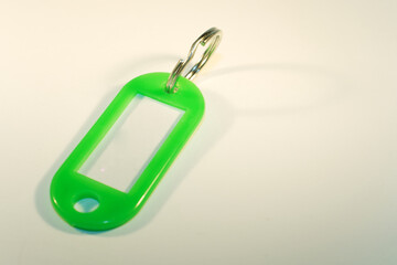 Fototapeta na wymiar Empty green key ring tag on a white background 