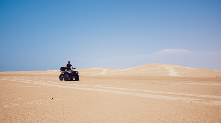 Anonymous man riding ATV in desert