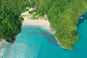 island with a jungle and a turquoise lagoon, aerial view. Caramoan Islands, Philippines. Small white sand beach.