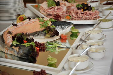 Buffet with salmon and prawns and salad with decorated ham and bowls of quails eggs to the side