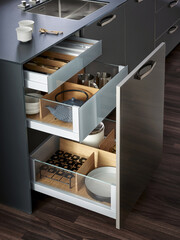 Fototapeta na wymiar Modern kitchen, Open drawers, Set of cutlery trays in kitchen drawer. Solid oak wood cutlery drawer inserts.