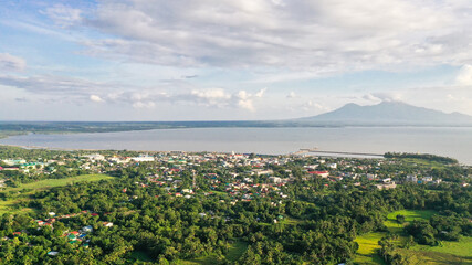 View of a small town and a volcano in the distance. Sorsogon City, Luzon, Philippines. Summer and travel vacation concept.
