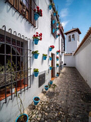 Fototapeta premium narrow street in the old town of Granada with Old Albaicin buildings, Spain