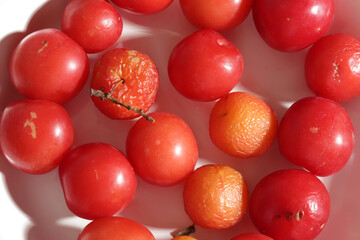 red colored fresh and crumpled plums