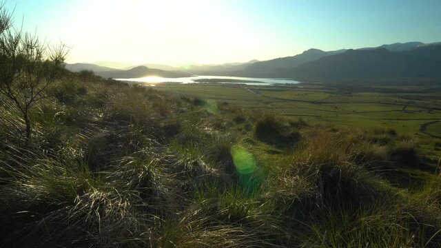 Sunset in the mountains with water lake in the valley and sun rays in the blue sky. Navacerrada Madrid.